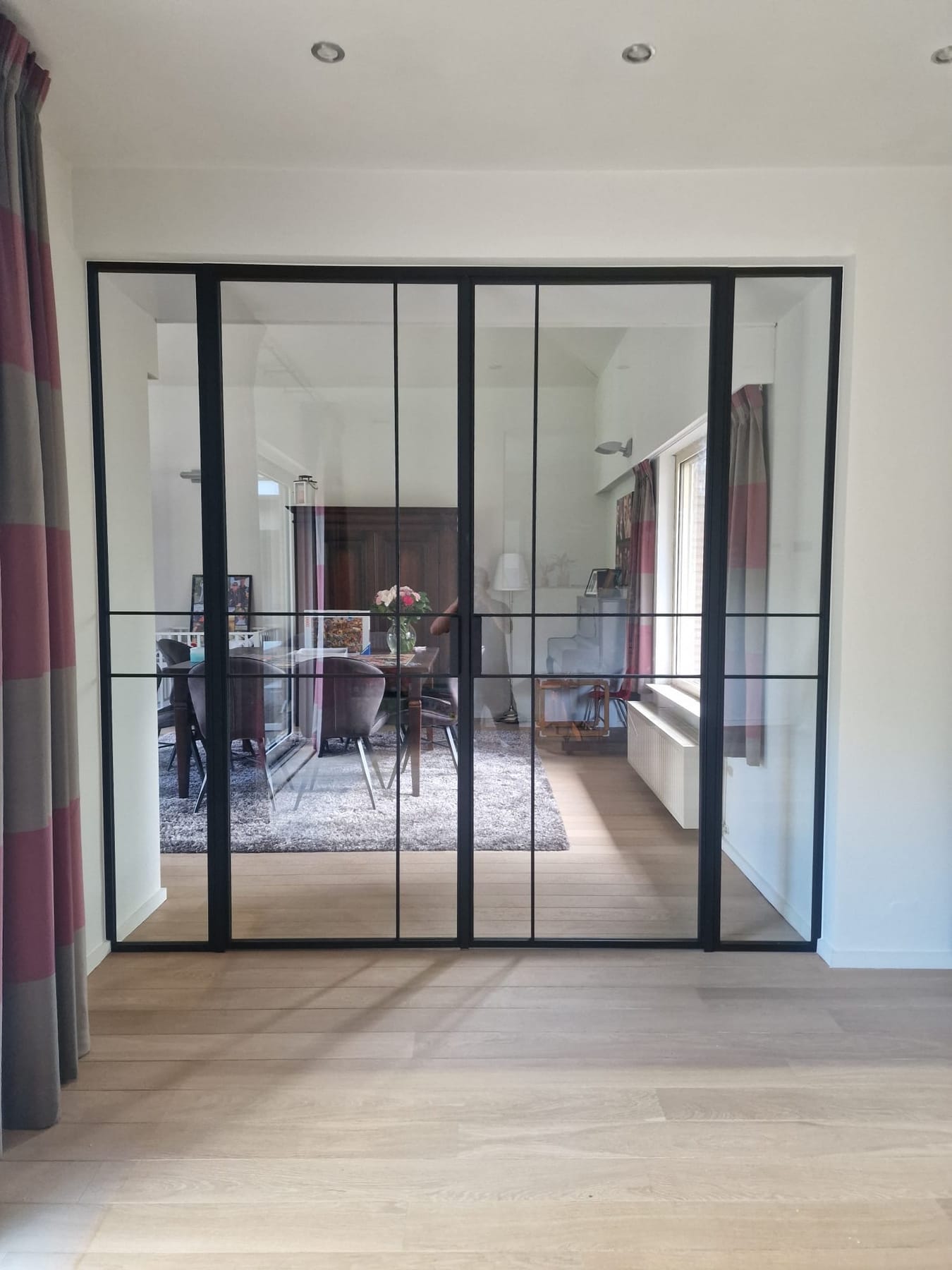 Zwarte stalen dubbele binnendeur met glas in een moderne woonkamer